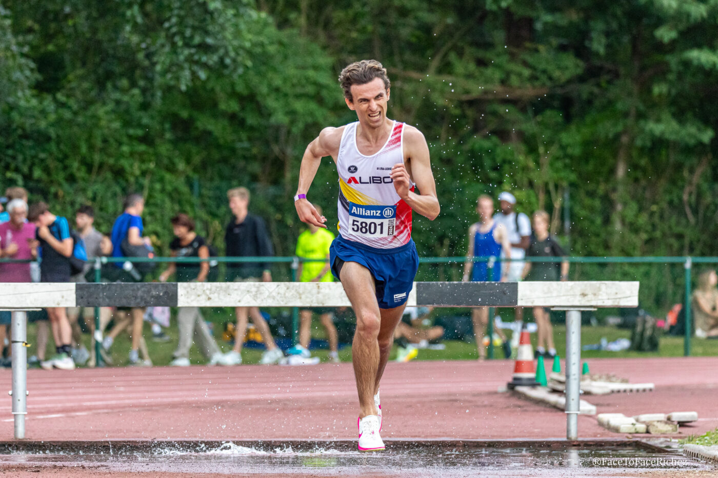 Tibo Vanleke clearing a water jump during a steeplechase race.