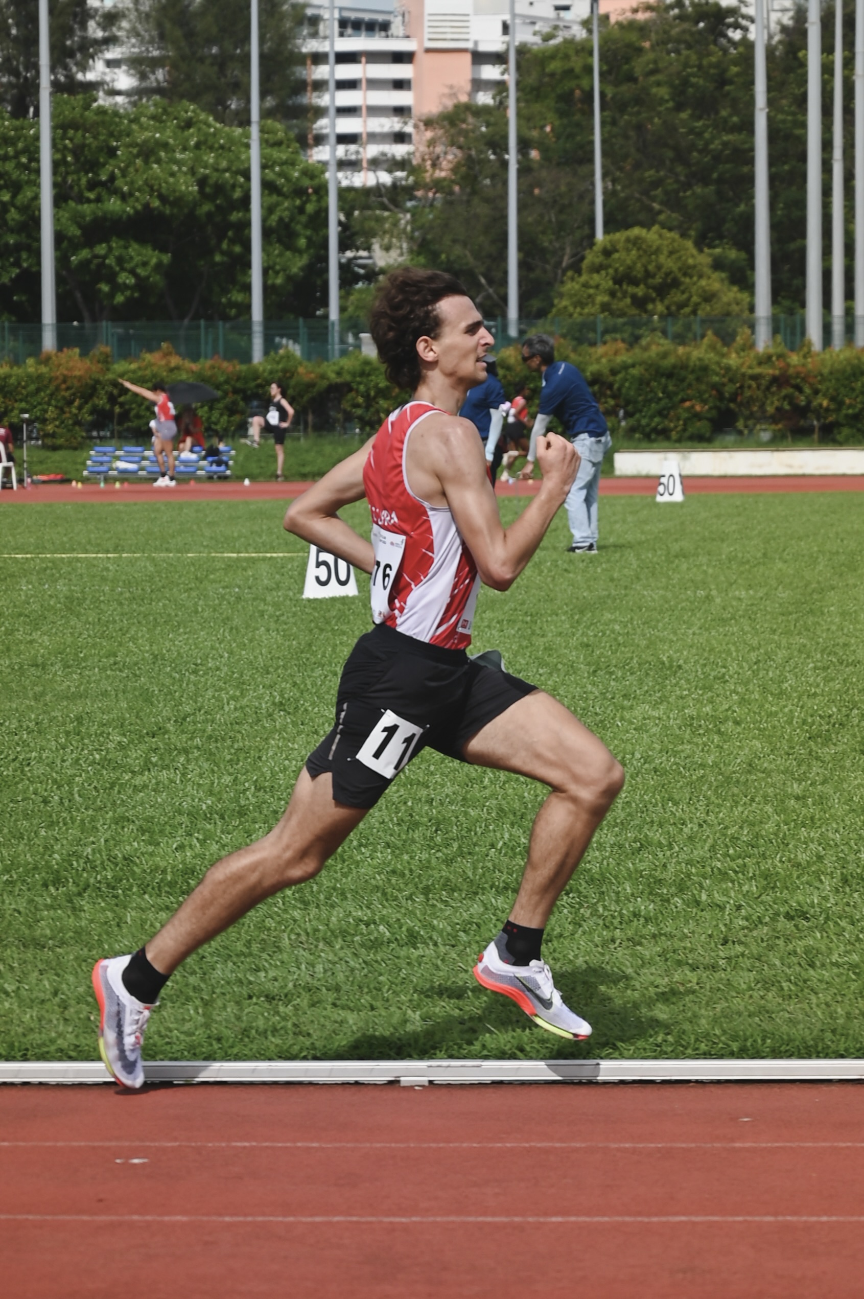 Side-profile running photo of Tibo Vanleke striding on the track.