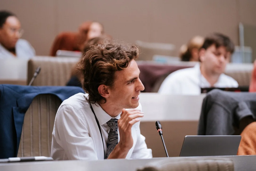 Tibo Vanleke contributing during a formal round-table discussion.